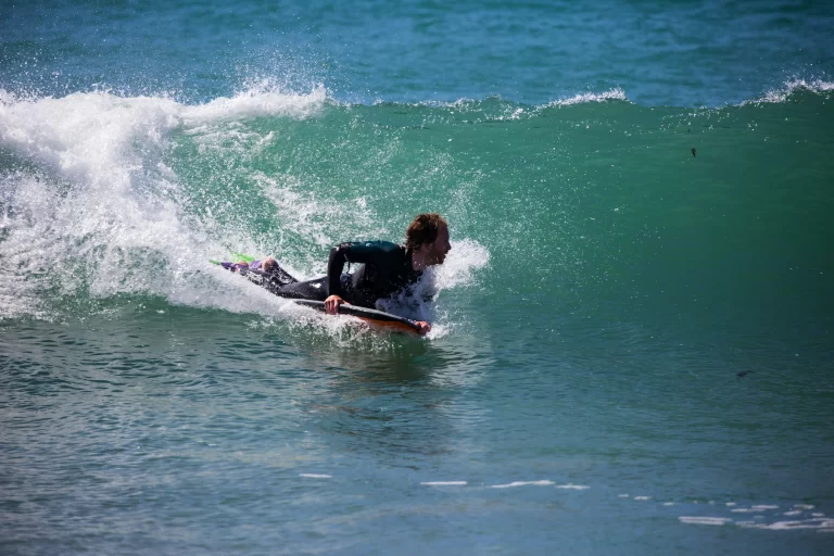 Hombre surfeando una ola con tabla de bodyboard