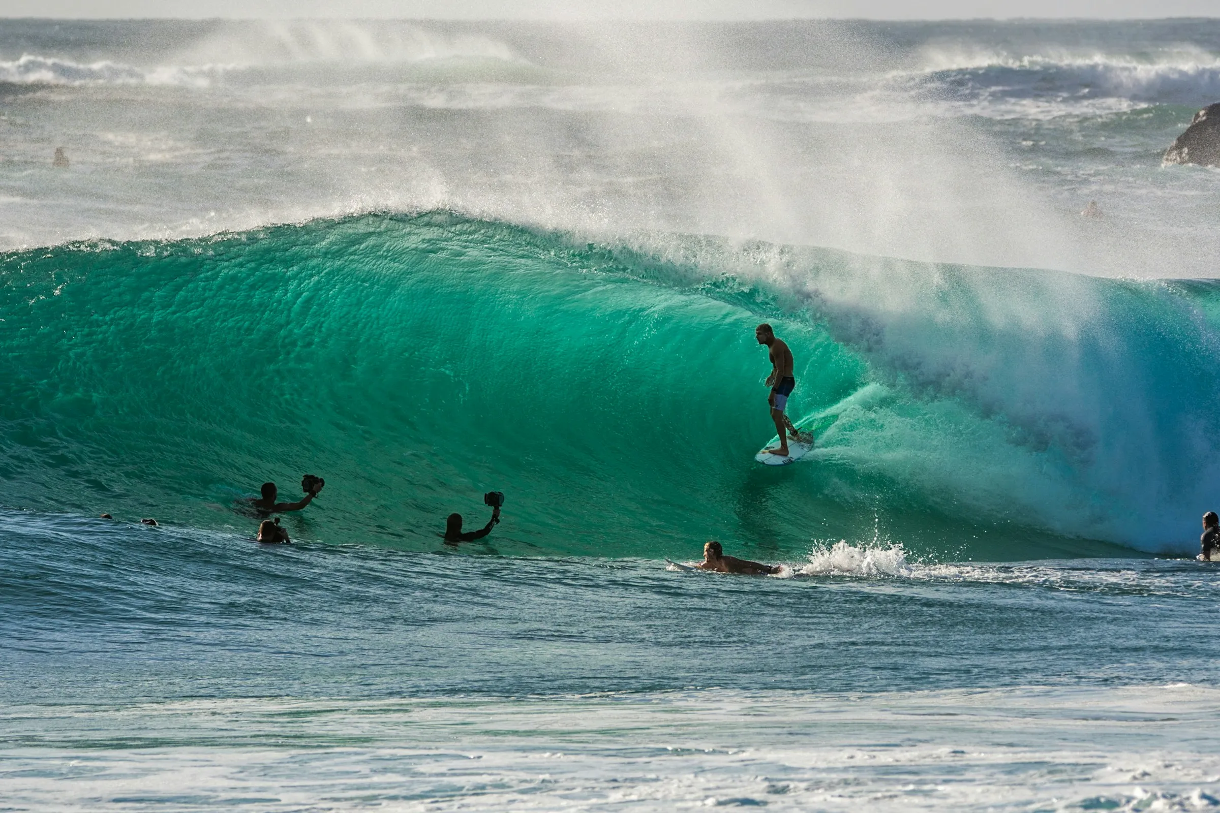 hombre surfeando una ola mientras es grabado