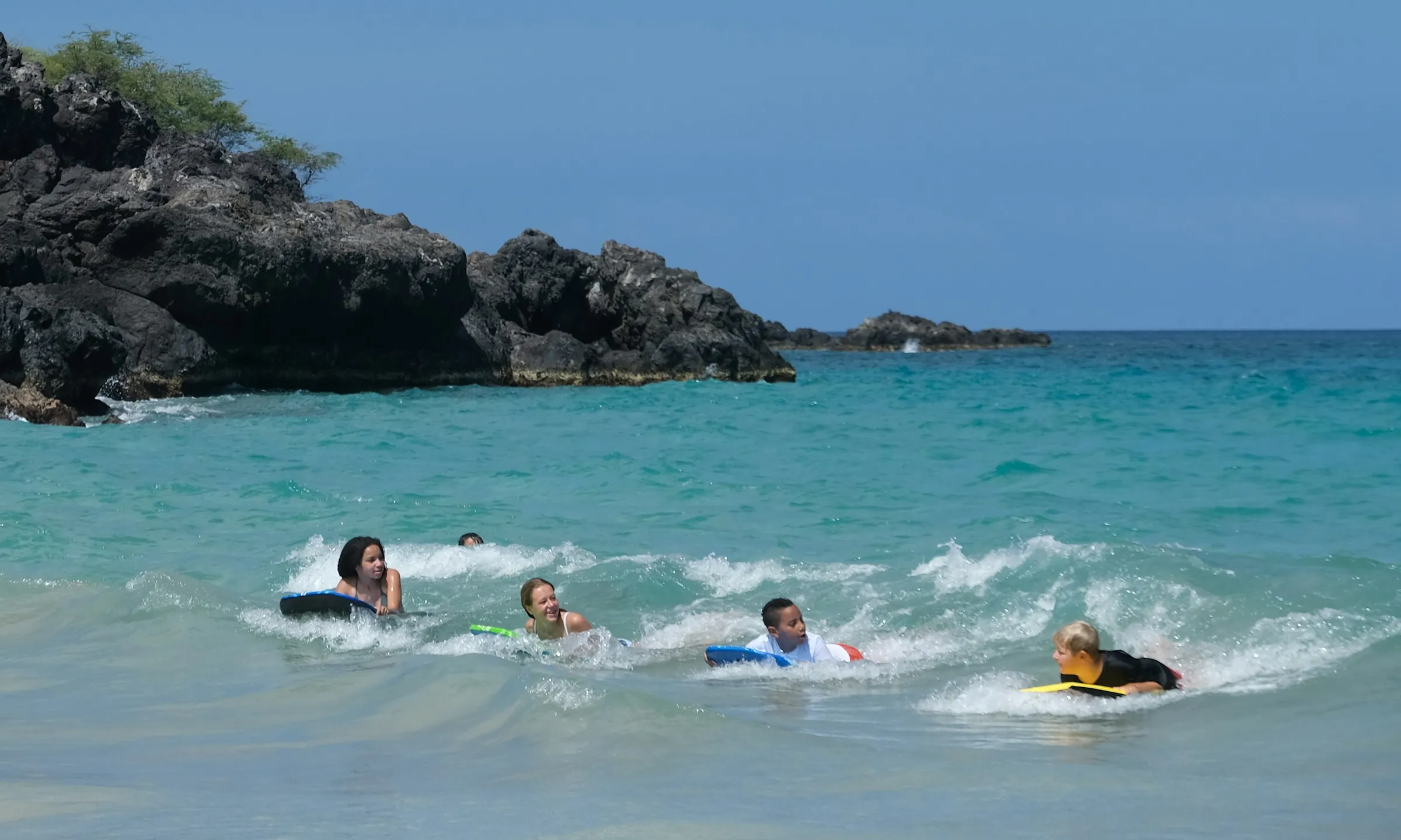 familia practicando bodyboarding en la playa